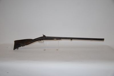 a rifle on a table with a white background