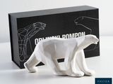 une figurine d'ours polaire blanc devant une boîte noire