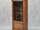 un vieux meuble en bois surmonté d'une porte en verre