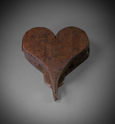 an old wooden heart shaped box sitting on top of a table