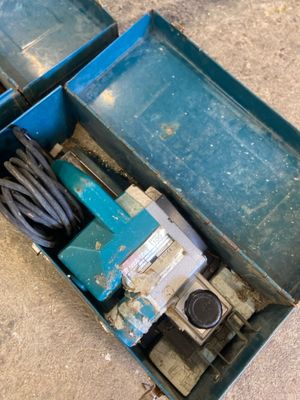 a blue box that has a drill and a cord in it