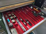 a drawer full of pens and other office supplies