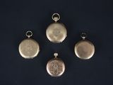 four antique silver pocket watches on a black background