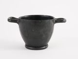 an old black cup with handles on a white background