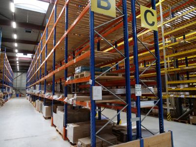 un grand entrepôt rempli d'étagères et de palettes