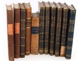de nombreux livres anciens alignés les uns à côté des autres sur une surface blanche