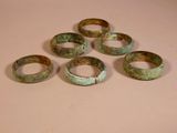 six pieces of ancient bronze bracelets sitting on a table
