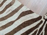 a zebra rug on the floor next to a tiled wall
