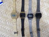 three watches sitting on top of a wooden table next to each other