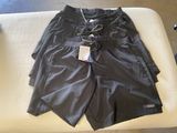men ' s black swim shorts on a white couch in a room