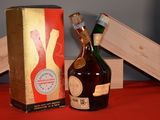 a bottle of liquor sitting next to a box on a table
