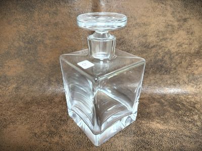 a clear glass bottle with a glass stopper on top of it