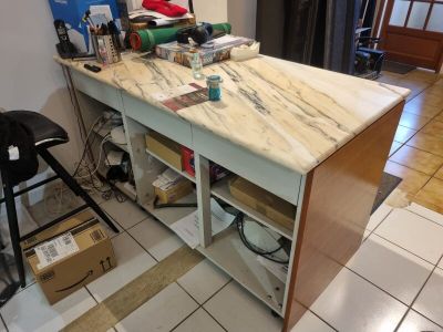 a kitchen island with a marble top in the middle of a room