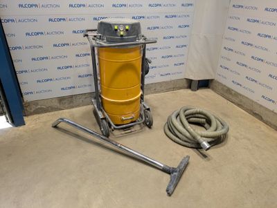 un aspirateur et un tuyau posés par terre près d'un mur