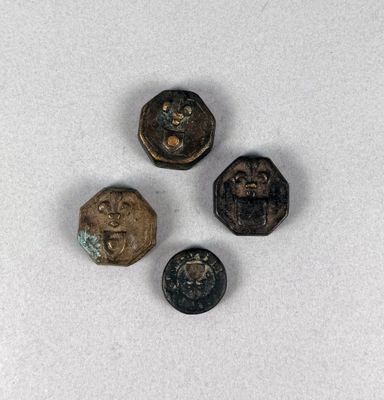 trois petits boutons métalliques posés sur une surface blanche