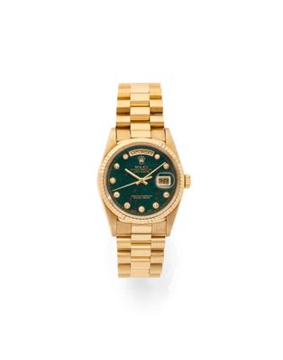 une montre Rolex avec un cadran vert et un bracelet en or