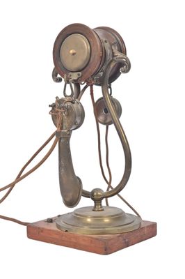 un téléphone à l'ancienne posé sur un socle en bois
