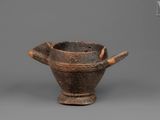 an old wooden bowl with a wooden handle on a gray surface