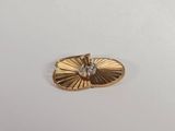 une broche plaquée or ornée d'un diamant au centre
