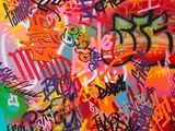 peinture représentant un graffiti sur un mur recouvert de nombreuses inscriptions