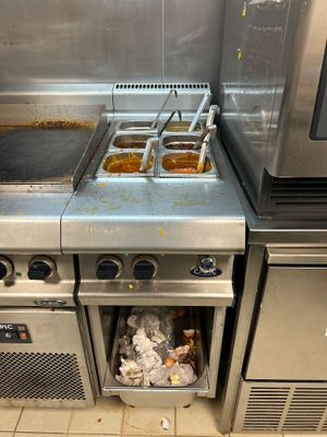 des cuisinières et des fours en acier inoxydable dans une cuisine professionnelle, contenant des aliments