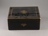 a small black box with a gold decoration on it
