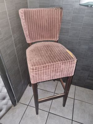 une chaise rose posée dans un coin de la salle de bains