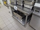 several pans are stacked on a metal shelf in a commercial kitchen