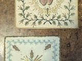 deux broderies posées sur une table, représentant un cœur et une croix