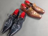 two pairs of men ' s shoes are lined up on a table