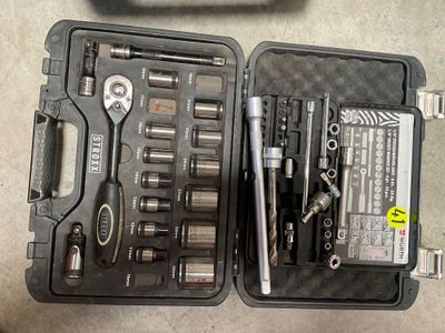 une trousse à outils dans un coffret posé par terre