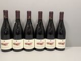 six bouteilles de vin rouge alignées sur une table
