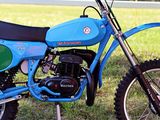 a blue dirt bike parked on the side of the road