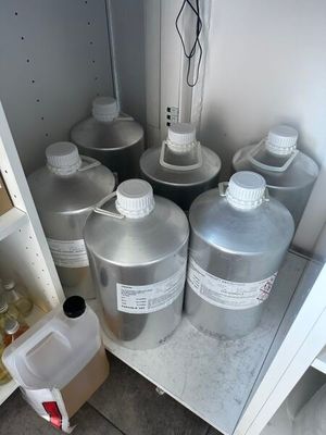 many cans of liquid sitting in a cabinet next to each other
