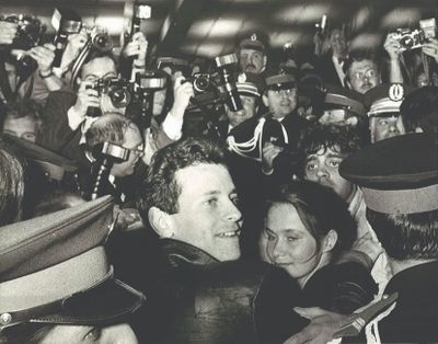 photographie en noir et blanc d'une foule de personnes brandissant des bouteilles de bière