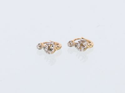 une paire de boucles d'oreilles en diamant sur une surface blanche