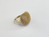 gros plan d'une bague en or sur une surface blanche