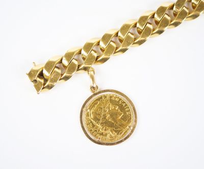 Gros plan sur un bracelet en chaîne en or sur lequel se trouve une pièce de monnaie