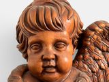 a wooden statue of an angel with wings on it ' s head