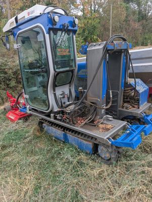 un tracteur qui est garé dans l'herbe près d'un bateau