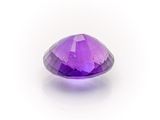 a close up of a purple diamond on a white surface