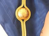 a close up of a tie with a gold button on it