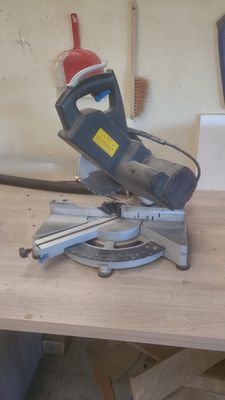 quelqu'un utilise une scie circulaire pour couper une pièce de bois