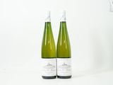 deux bouteilles de vin posées l'une à côté de l'autre sur une surface blanche