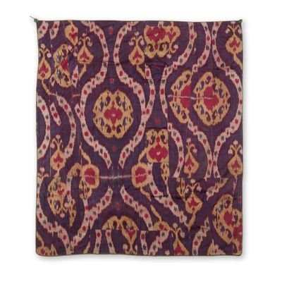 un gros plan sur un coussin violet et rouge orné d'un motif