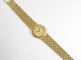 a close up of a gold wrist watch on a white surface