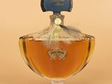 an image of a bottle of perfume sitting on top of a table