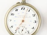 a silver pocket watch on a white surface with numbers