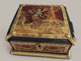 a small box with a painting on it on a table