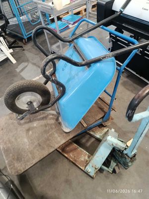 a blue wheelbarrowr sitting on a pallet in a warehouse